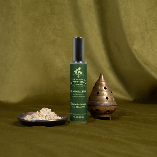 Frankincense aromatherapeutic ritual spray bottle styled with botanicals in natural light