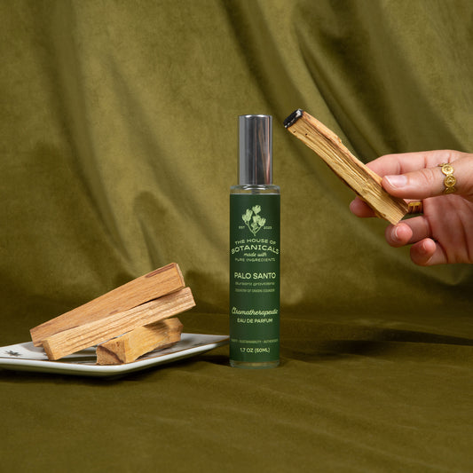 Palo Santo ritual spray with palo santo sticks, a hand holding a stick of the wood